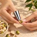 Stainless steel pistachio opener worn on a finger to open a pistachio shell